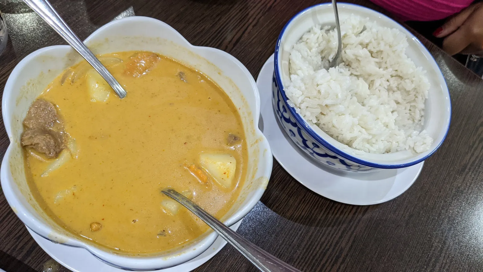 Massaman curry with beef and potato alongside a bowl of steamed rice